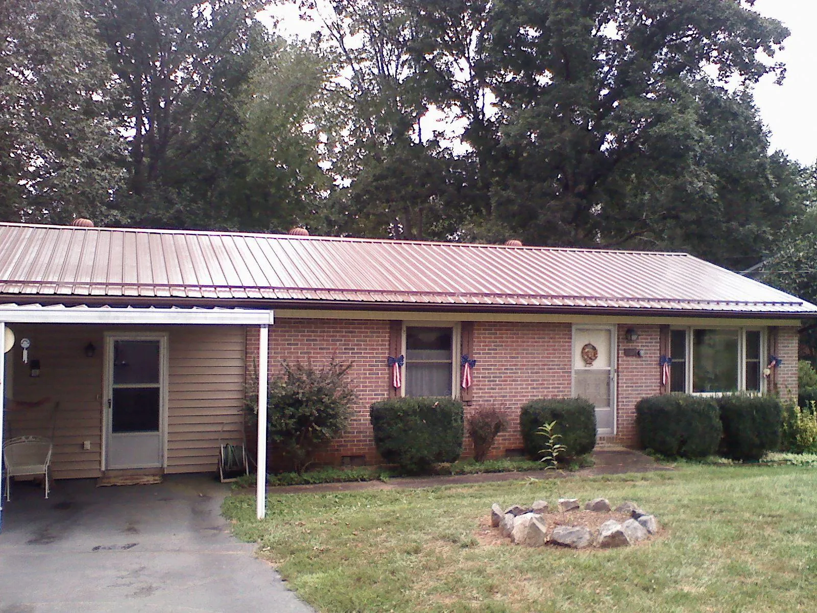 Bronze metal roof and carport on a brick ranch home — Roof Repair work by our crew in Glyndon